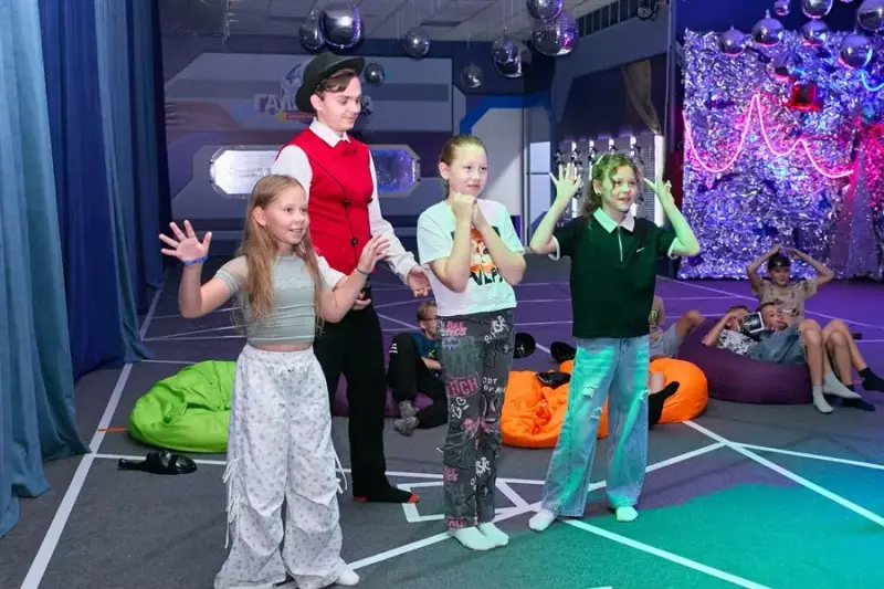 Ведущий в цилиндре играет с детьми